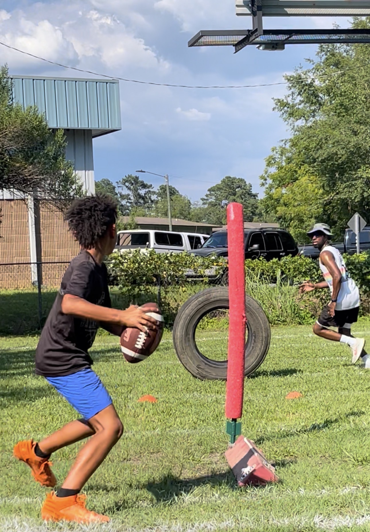 Football player working ball-handling and footwork around a tackle dummy