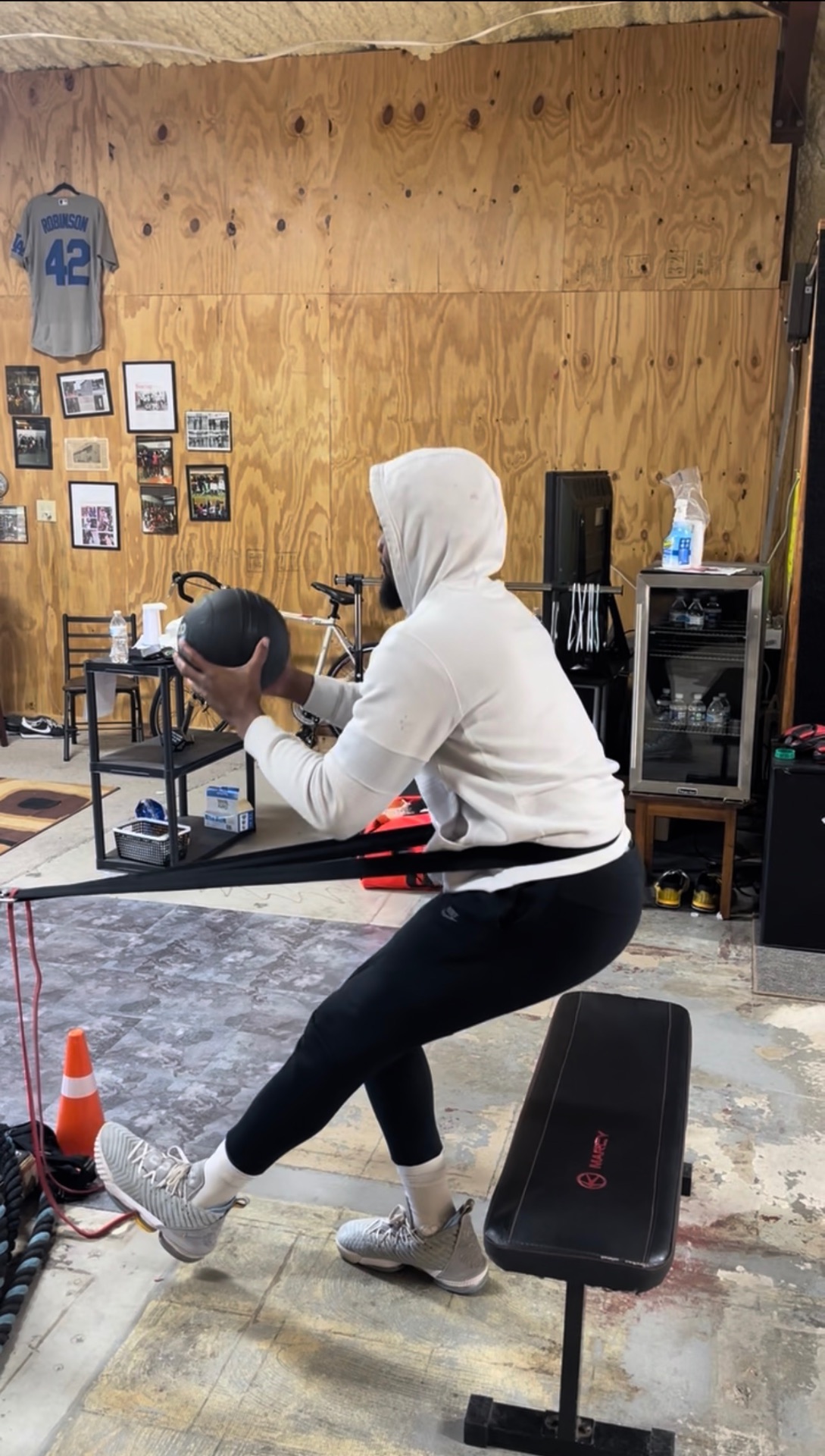 Athlete doing banded medicine-ball squats during strength training