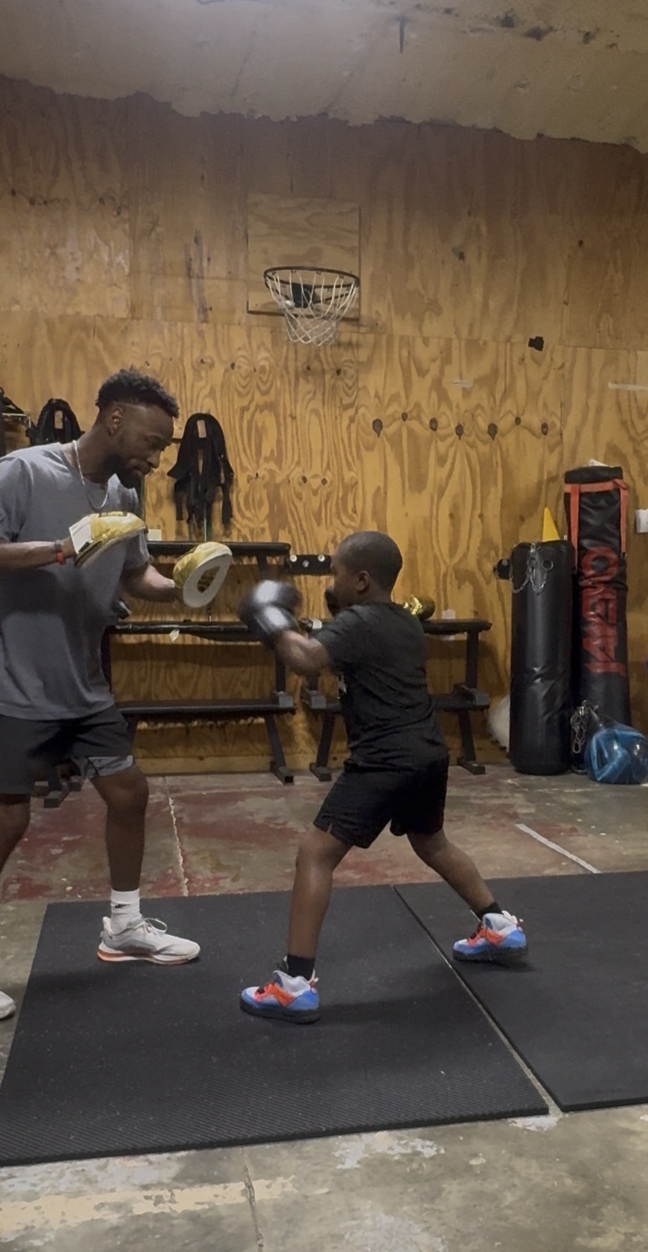 Young Fit Fighters boxer throwing a punch on the mitts with Coach Dom