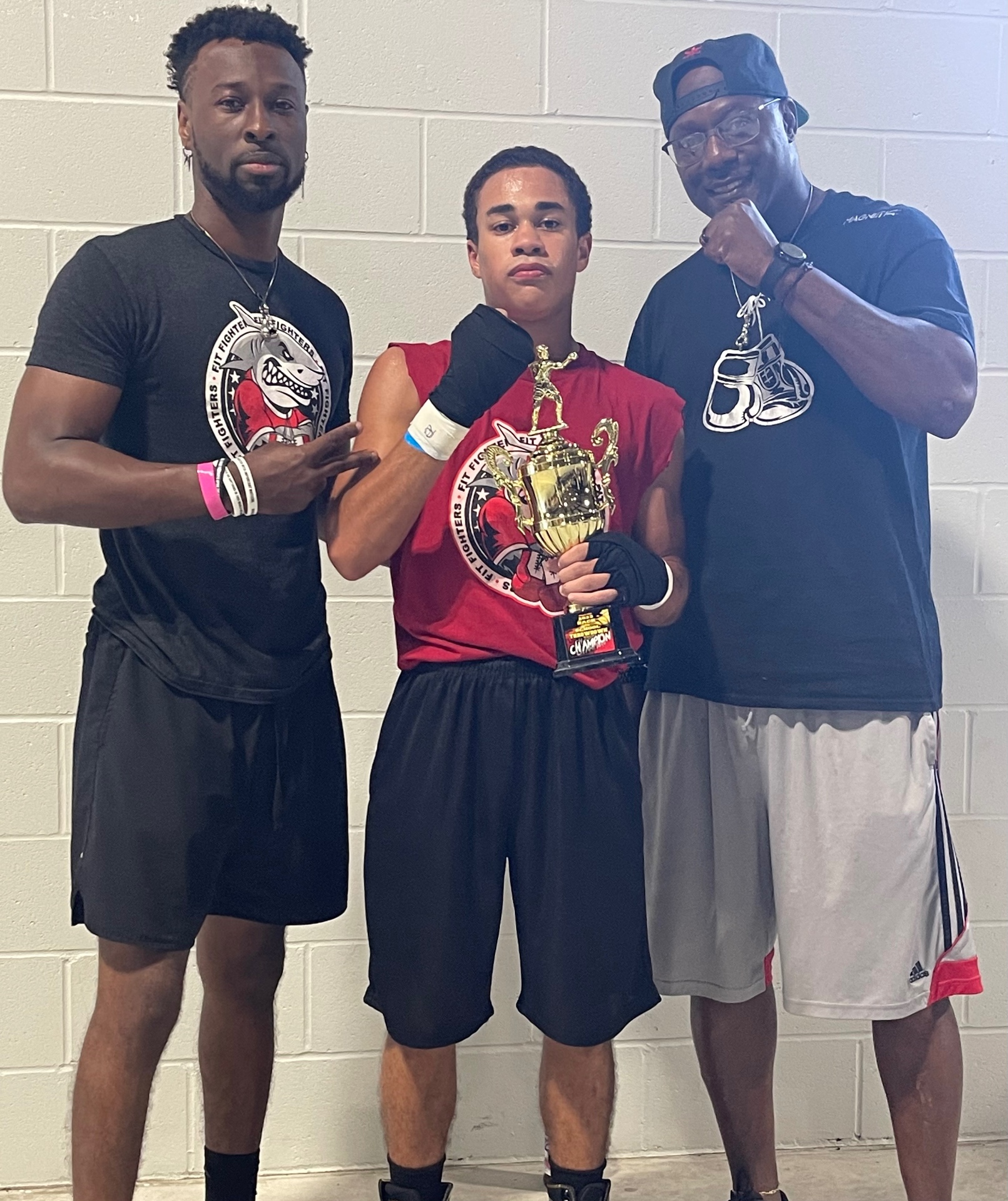 Young Fit Fighters boxer with championship trophy and coaches