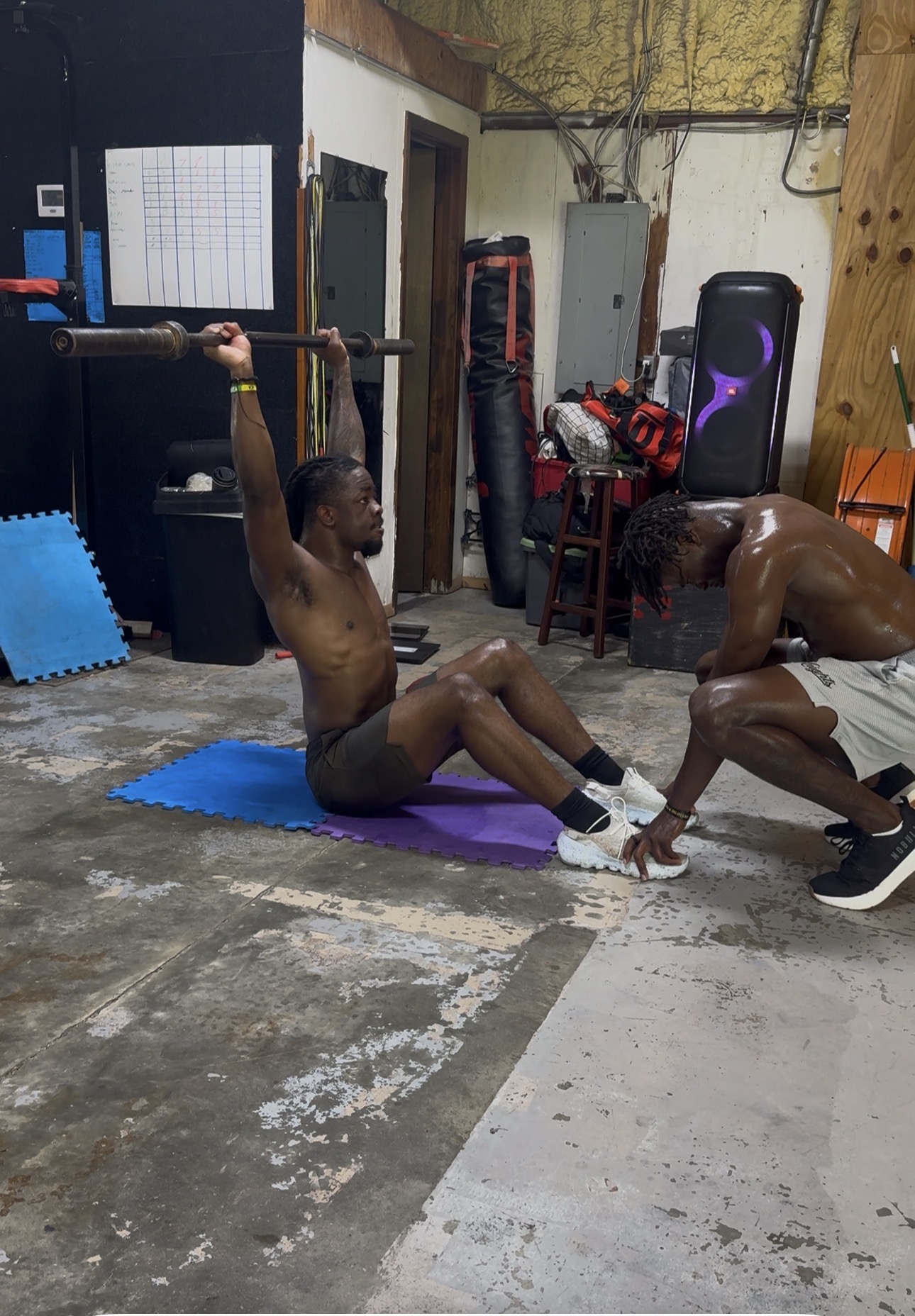 Athlete doing weighted core work with a partner spotting