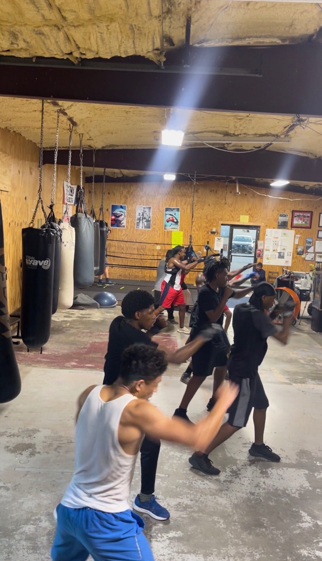 Group boxing workout at Fit Fighters with heavy bags and drills