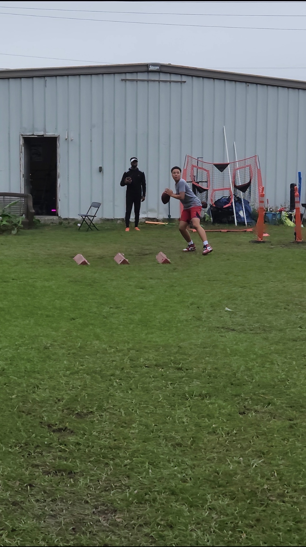 Young quarterback dropping back to throw during outdoor football training