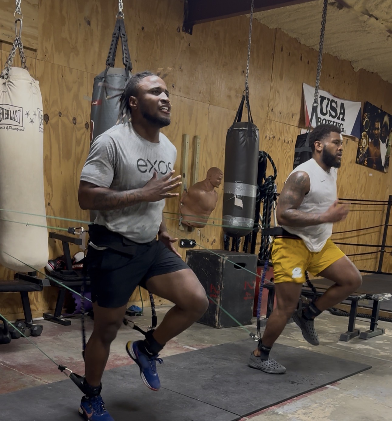 Athletes doing resistance-band sprint drills in the gym