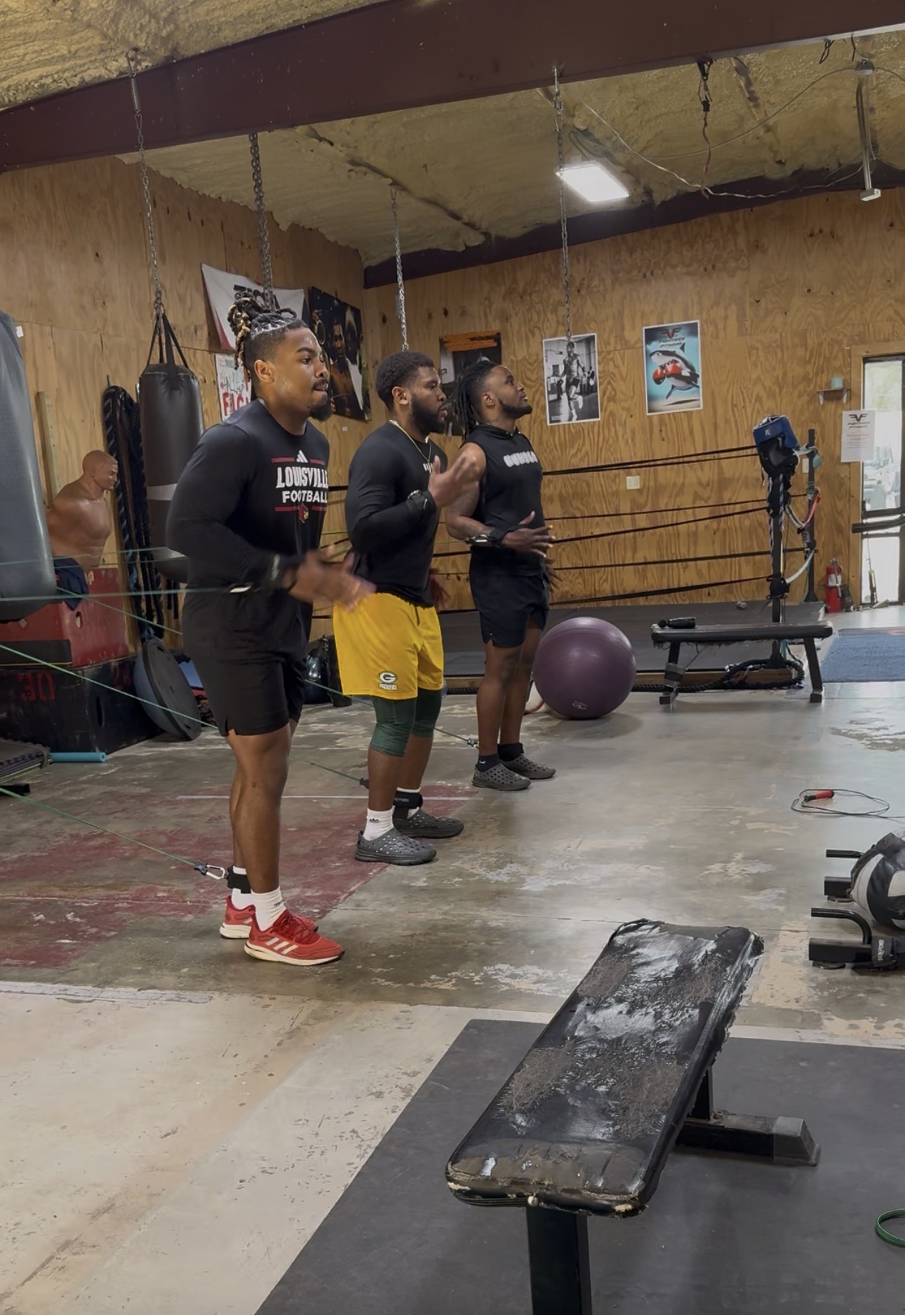 Football players doing resistance-band conditioning work in the gym