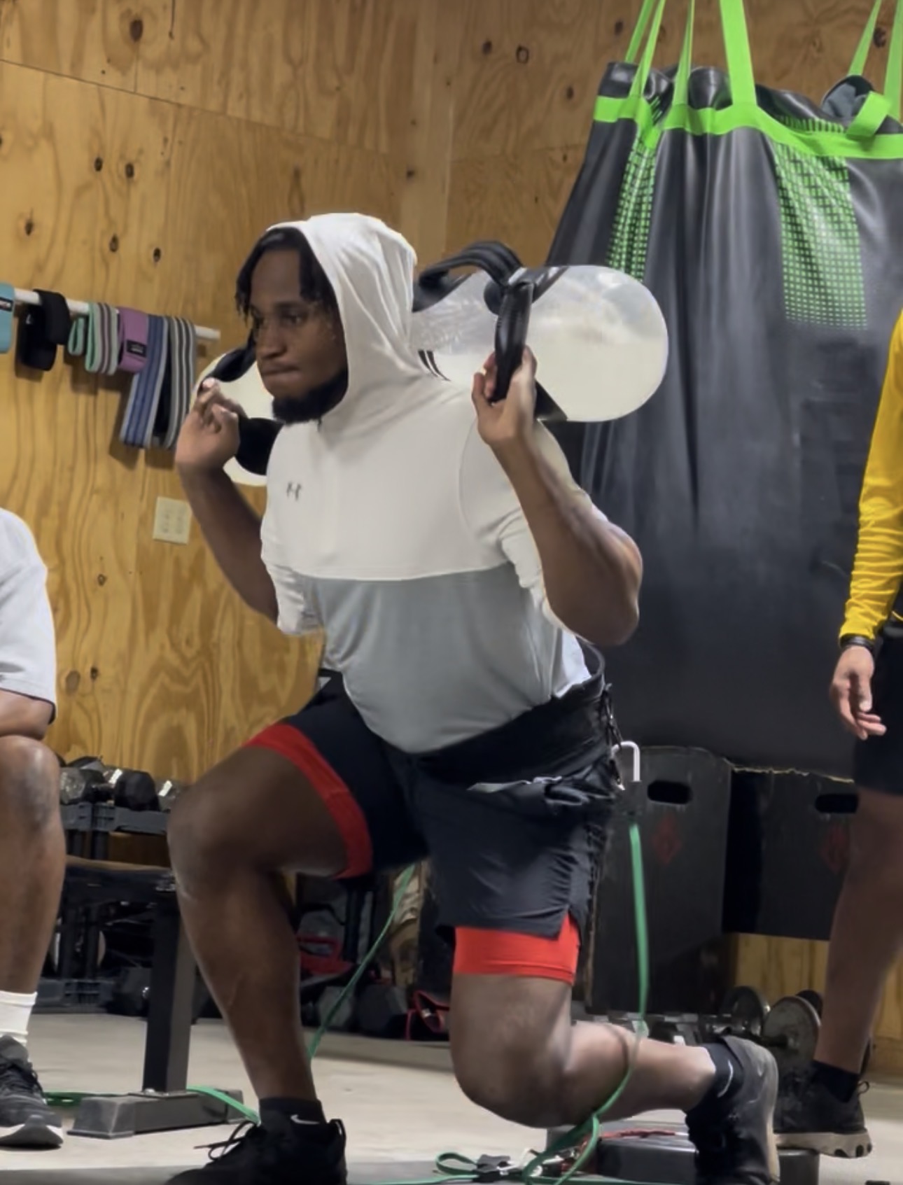 Athlete doing weighted split-squat lunges with a heavy bag