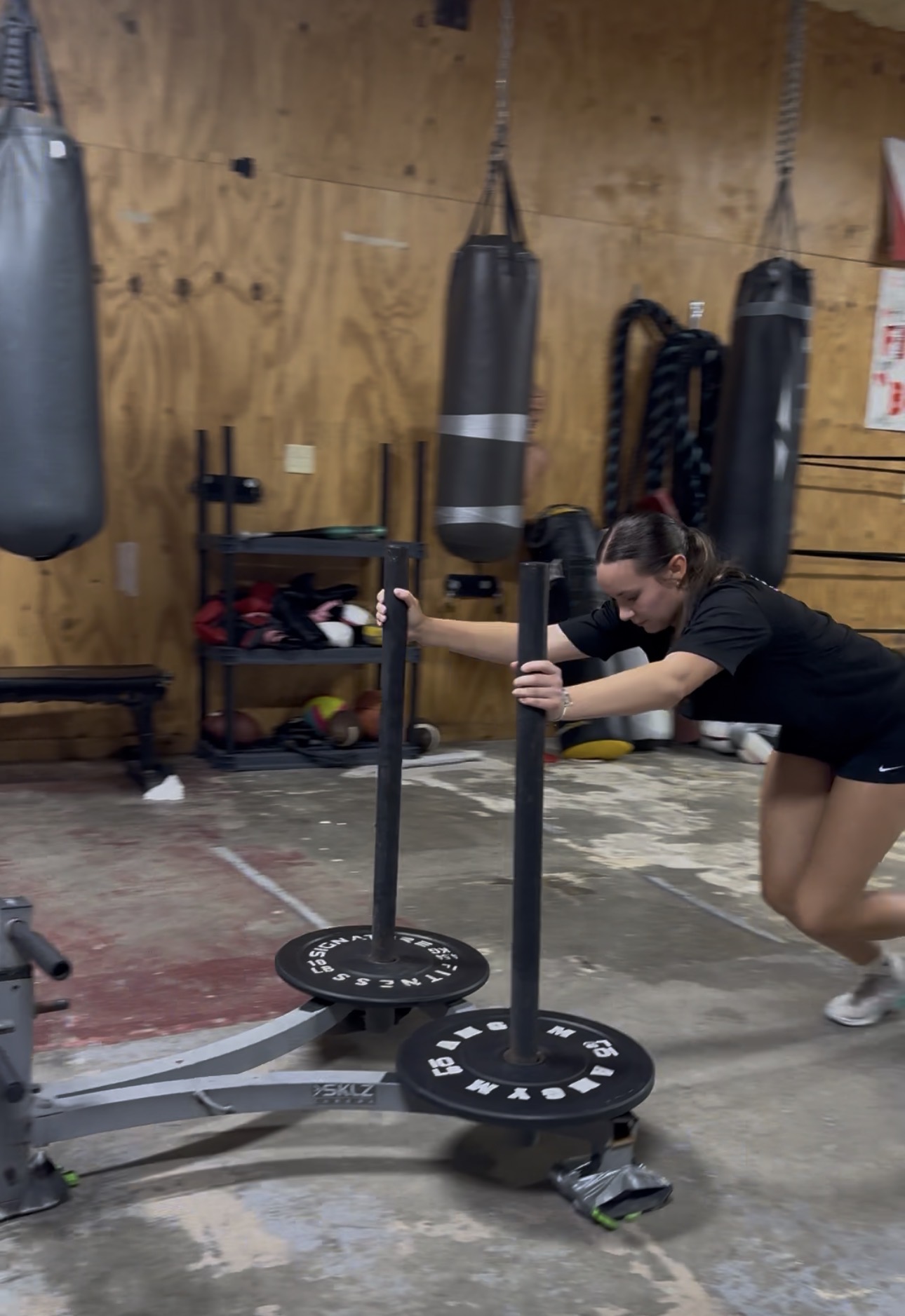 Athlete pushing a weighted sled during conditioning training