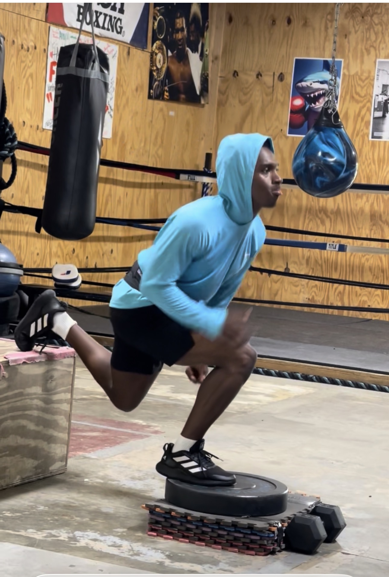 Athlete doing single-leg balance work on a plate in the boxing gym