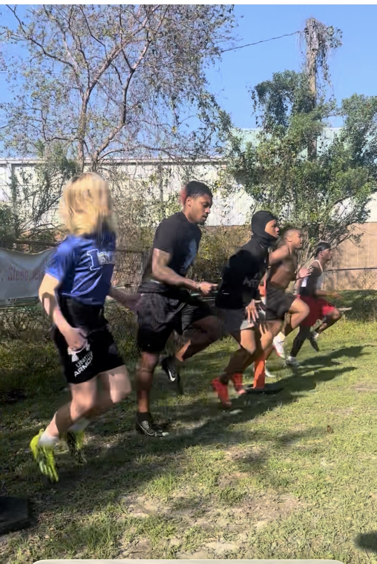 Group of athletes sprinting together during outdoor conditioning