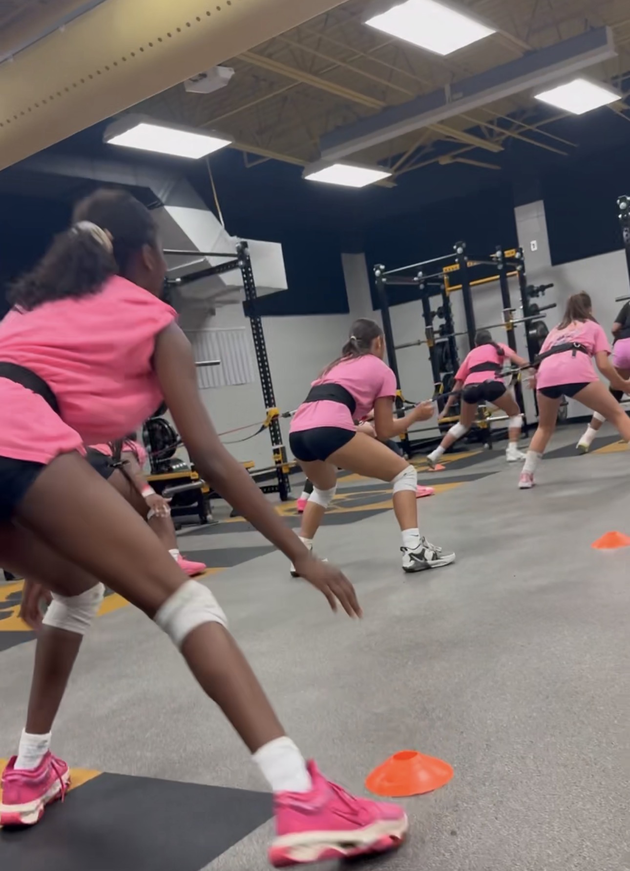Athletes doing lateral agility and cone drills in the gym